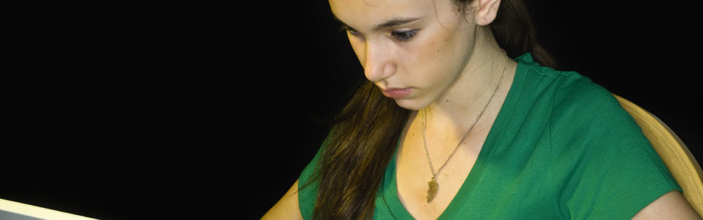 A teenage girl concentrates as she uses her laptop to take the ZAPS ACT-Practice Test.